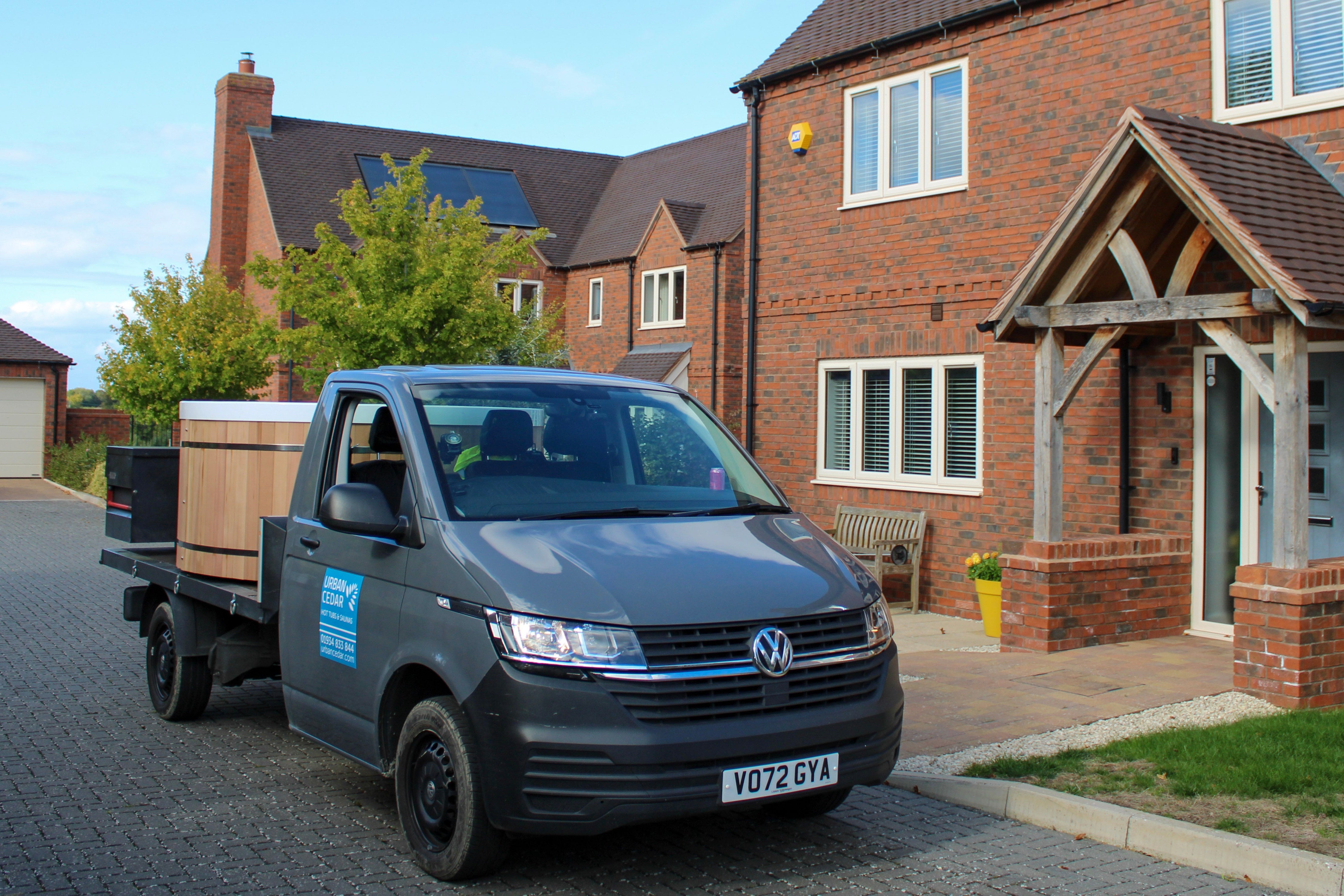 Volkswagen van with a wooden crate on a driveway in front of a house